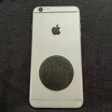 Shungite Flower of Life EMF Protector disc on back of a phone
