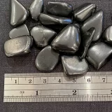 Small Shungite Tumble Stones next to a ruler